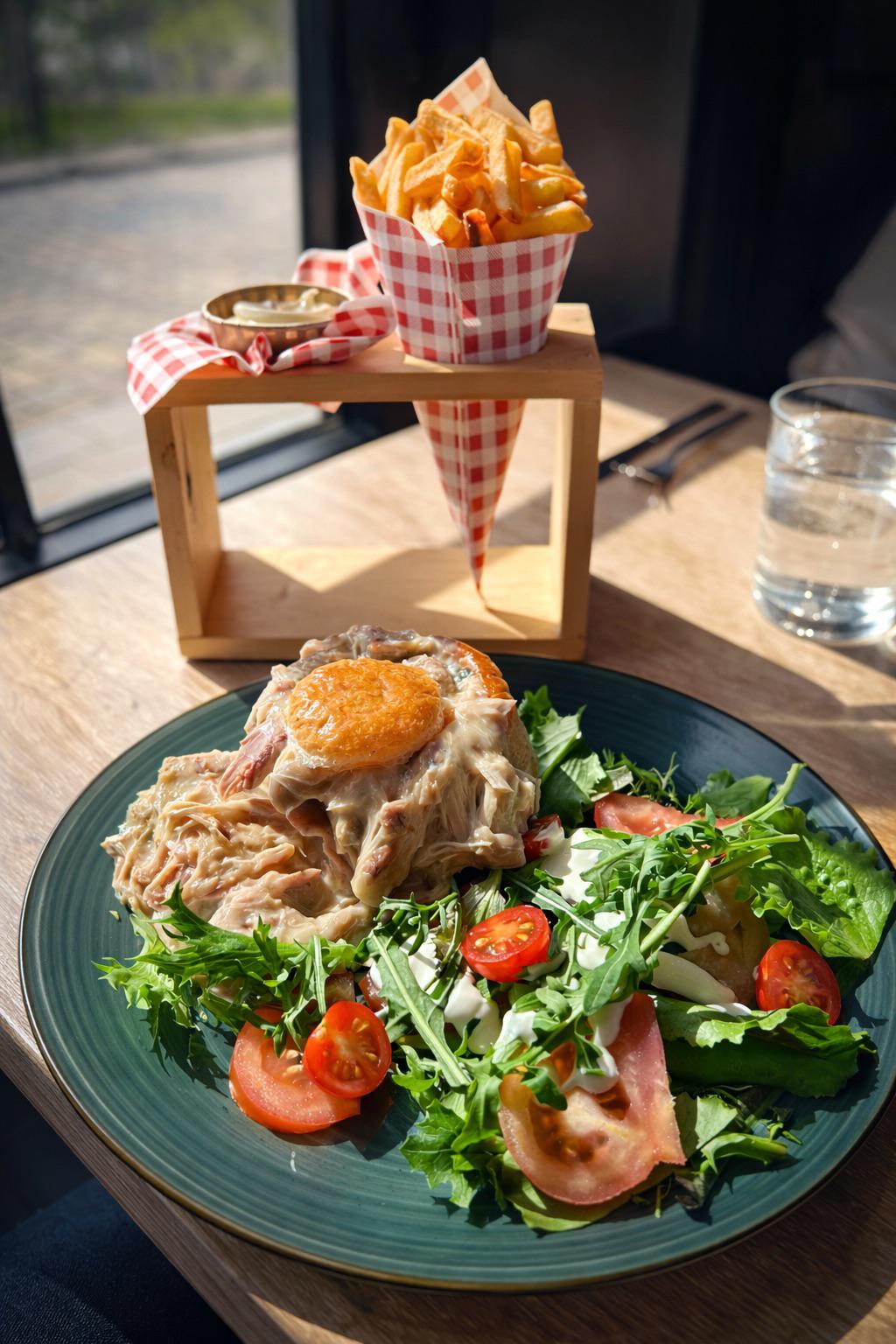 Lunchgerecht van La Terrasse 364 met huisgemaakte salade en knapperige frietjes