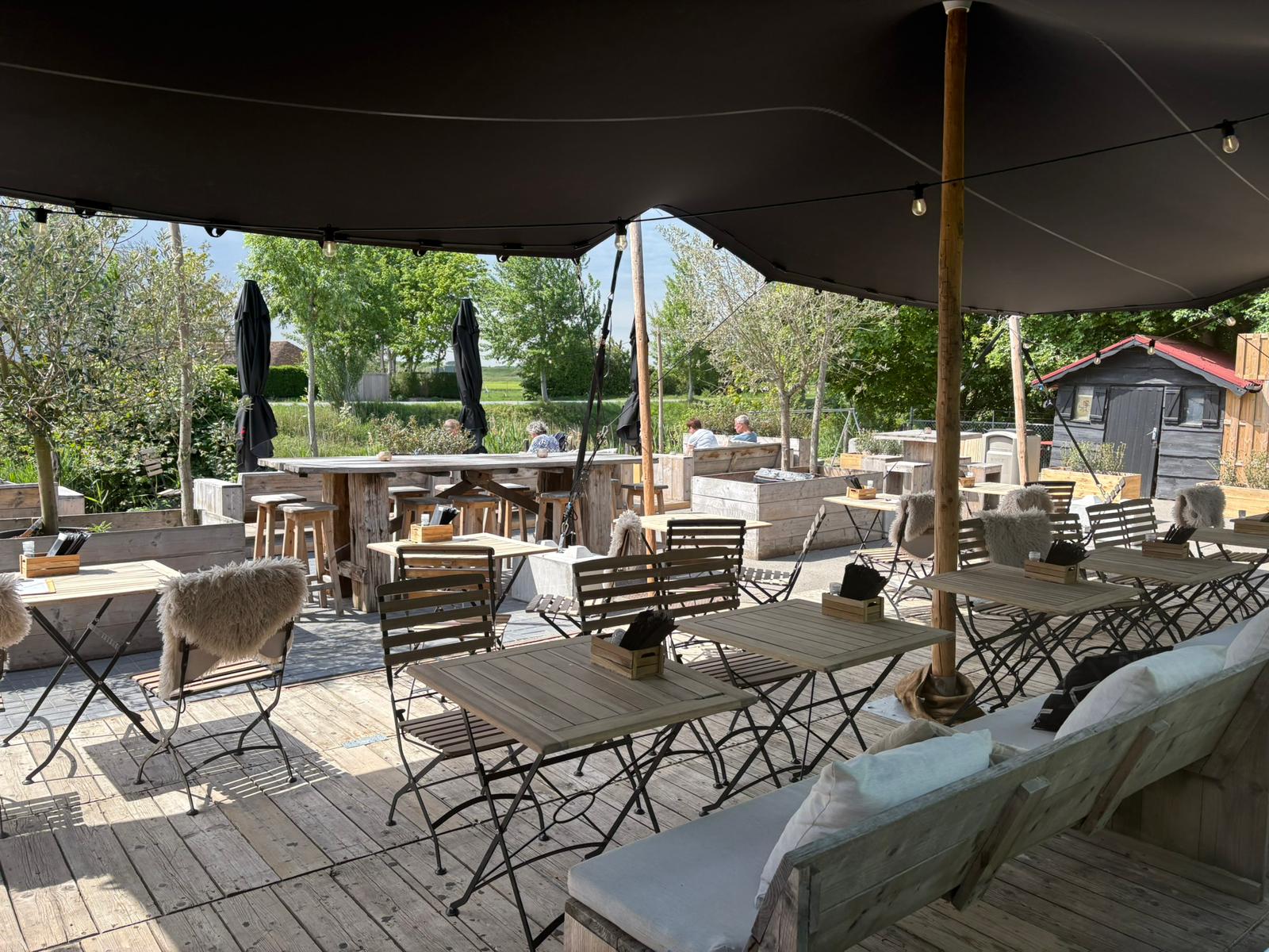 Terras onder de stretchtent met uitzicht op de polder